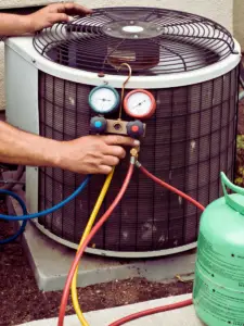 AC Tech using AC manifold gauge on outside air condenser unit